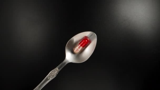Red White Pill Capsule Spoon Black Background Top View Dolly — Vídeo de Stock