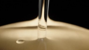 I pour water on a golden spoon, a drop of water. Dolly slider extreme close-up. Laowa Probe