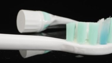 Electric Toothbrush, lies on a black table and vibrates. Dolly slider extreme close-up. Laowa Probe