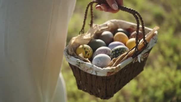 Woman Holds Knitted Basket Painted Easter Eggs Forest Background Green — Stockvideo