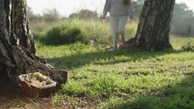 A man and a woman in the forest are racing to a basket of Easter eggs,