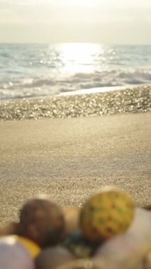 Sunset on the beach by the sea, the focus shifts from the background to the Basket with Easter eggs. Vertical video Social Media