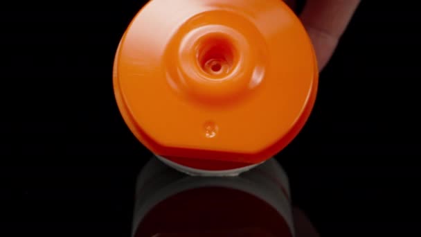 黒いテーブルの上にオレンジのチューブから白いクリームを絞る ドリースライダー極端なクローズアップ ラオワプローブ — ストック動画
