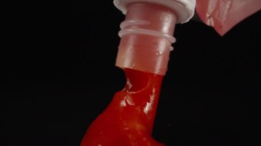 Squeezing ketchup on the black table. Dolly slider extreme close-up. Laowa Probe