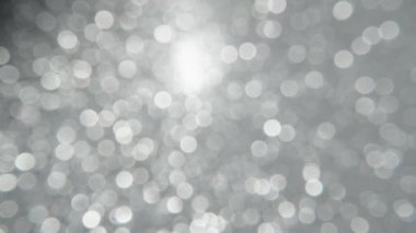 Silver bokeh circles, shimmer. Macro footage.