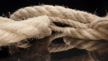 Jute rope on black table. Dolly slider extreme close-up. Laowa Probe