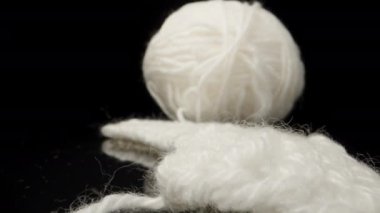A ball of white woolen threads on black glass... Dolly slider extreme close-up. Laowa Probe