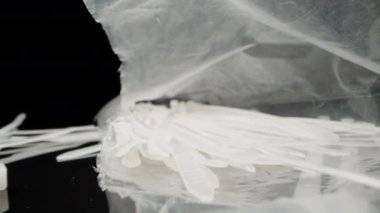 White nylon cable ties in a bag. Dolly slider extreme close-up. Laowa Probe
