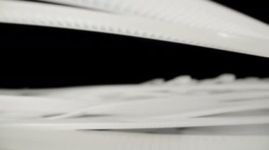 White nylon ties fall onto the table. Dolly slider extreme close-up. Laowa Probe