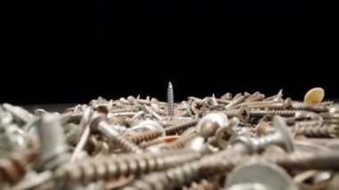 Old self-tapping screws and screws on the table. Super zoom on self-tapping screw. Dolly slider extreme close-up. Laowa Probe