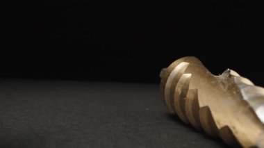 There is a set of stepped drills on the table, the camera flies through them. Dolly slider extreme close-up. Laowa Probe