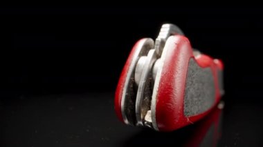 Red folding knife, on a black glass table, close-up.