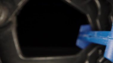 Plastic clip, clothespin on a black background. Dolly slider extreme close-up inside. Laowa Probe