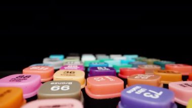 Multi-colored markers with the name of the colors on the lids. Dolly slider extreme close-up. Laowa Probe