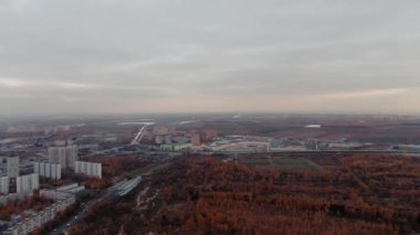 Autumn in the city, drone video. Red trees in cloudy weather. urban landscape