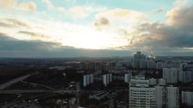 Drone video, cityscape at sunset. Smoke from factory chimneys.