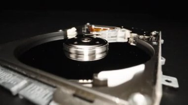 Disassembled computer hard drive, on a black background. Repair. Dolly slider extreme close-up. Laowa Probe