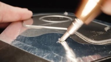 I open the seal and unscrew the screw of the computer hard drive, close-up.