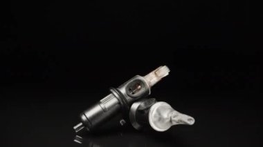 Needles for a tattoo machine, close-up. On a black background. Dolly slider extreme close-up.