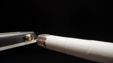 I screw the antenna into the wifi transmitter for the computer, close-up.