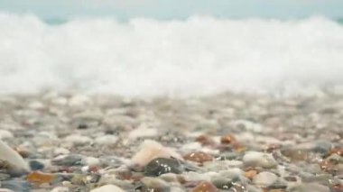 Kamera bir deniz dalgası ile kaplıdır. Su altında taşlar. Yavaş Hareket