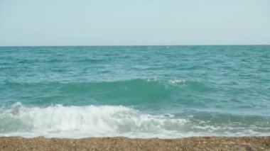 The blue sea is storming. The waves hit the shore.