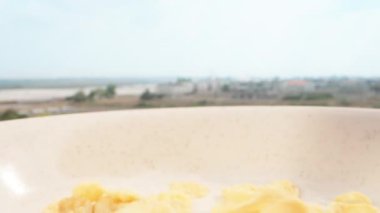 Breakfast under the open sky on the balcony on a sunny morning. I sprinkle with corn flakes. Dolly slider extreme close-up. Laowa Probe. Slow mo