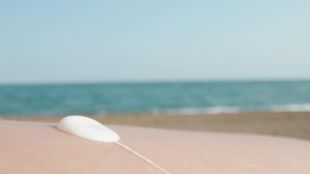Giovane Donna Sulla Spiaggia Che Applica Protezione Solare Alla Gamba — Video Stock