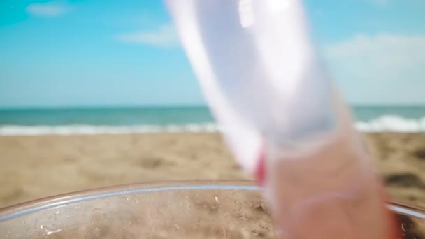 Versare Soda Rossa Bicchiere Sulla Spiaggia Sullo Sfondo Del Mare — Video Stock
