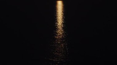 Strawberry supermoon over the sea. Reflection on the water. The boat sails in the light of the moon