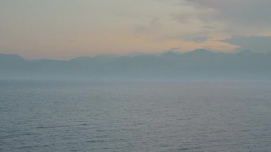 Landscape of mountains and sea at sunset. The plane flies very far.