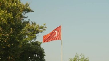 Türkiye 'nin Antalya' daki büyük bayrağı ağaçların arasında, gökyüzüne karşı.