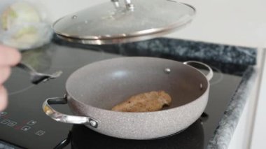 Pişirirken, tavuğun bir parçasını kızartma tavasına çeviriyorum, hareket halinde. Siyah çalı.