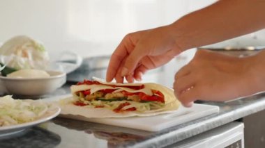 Yemek pişiriyorum, shawarma sarıyorum. Harekete geç. Siyah taş tezgah. Beyaz kesme tahtası.