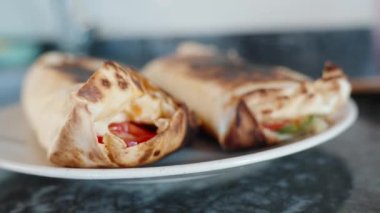 Yemek pişirme, tabakta iki kızarmış shawarma. Harekete geç. Siyah taş tezgah..