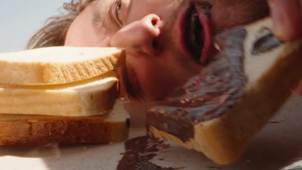 Homem Está Brincar Mordidas Torradas Com Pasta Chocolate Deitada Céu — Vídeo de Stock