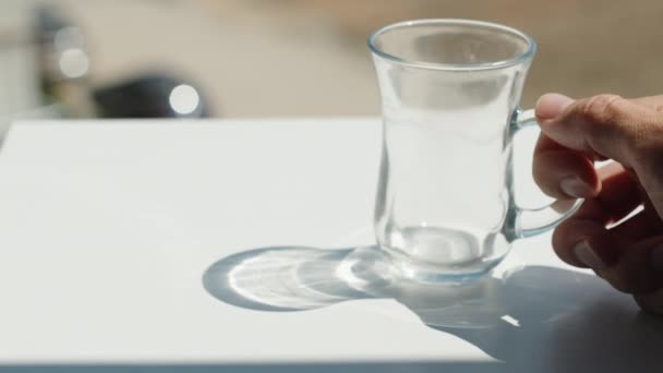 私は空のカップをテーブルの上に置き それに熱いお茶を注ぐ テーブルの上に影 — ストック動画