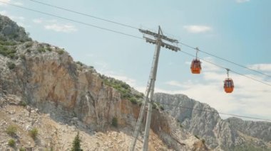 Kablolu araba, iki kırmızı funicular bir kayanın arka planında kesişiyor, yan görüş..