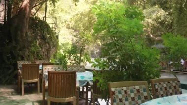Dağ nehri kıyısında bir kafe. Güzel doğa. Tahta mobilyalar. Yaz yürüyüşü. Hareket halinde..