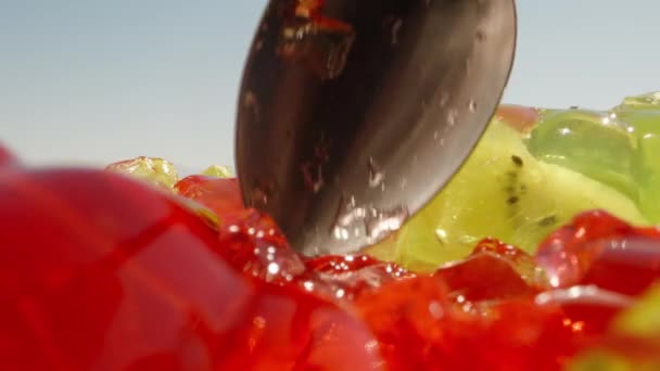 红色和绿色的果冻混合在一起 映衬着蓝色的天空 超级宏观 我用勺子吃红果冻 — 图库视频影像