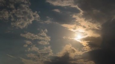 Güneş bulutların arkasında belirir ve kaybolur, güneş ışınları bulutların arkasında. Zaman turları