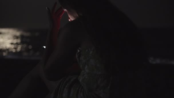 Młoda Kobieta Sukience Siedzi Nad Morzem Plaży Zagląda Smartfona Księżyc — Wideo stockowe