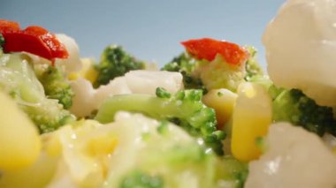 Sebze karışımı yukarıdan düşer. Sulu ve sağlıklı yiyecekler. Karnabahar, brokoli, mısır. Güneş parlıyor. Dolly Slider aşırı yakın çekim. Laowa Sondası