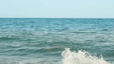 Dalgıç maskeli bir adam denizin derinliklerinden ortaya çıkar. Yavaş çekim