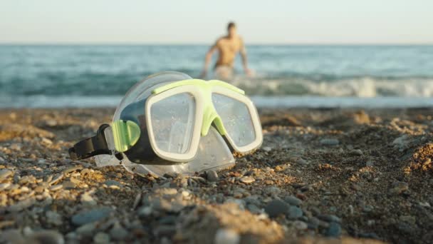 Uma Máscara Mergulho Está Deitada Areia Junto Mar Homem Sai — Vídeo de Stock
