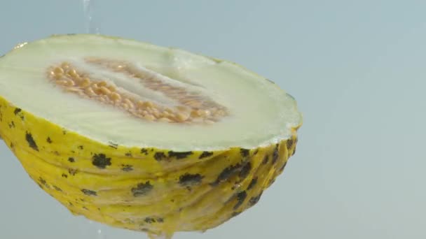 Polovina Žlutého Melounu Kostmi Voda Něj Vylita Proti Modré Obloze — Stock video