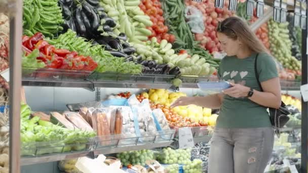Uma Jovem Mulher Uma Loja Vegetais Escolhe Cogumelos Recipiente Azul — Vídeo de Stock