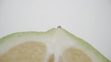 Beyaz arka planda kesilmiş yeşil limonun yarısı. Dolly Slider aşırı yakın çekim. Laowa Sondası