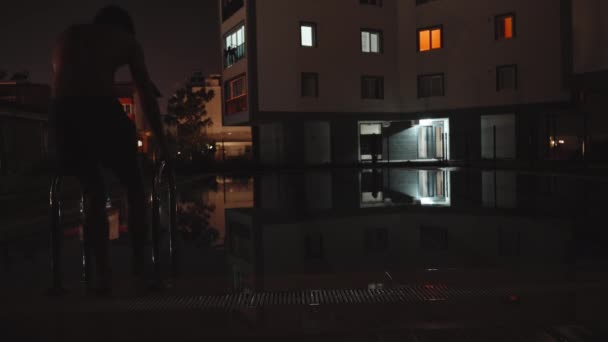 Mężczyzna Pływa Basenie Nocy Schodzi Schodami Basenu — Wideo stockowe
