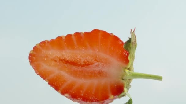 Eine Halbe Erdbeere Dreht Sich Vor Dem Hintergrund Des Blauen — Stockvideo
